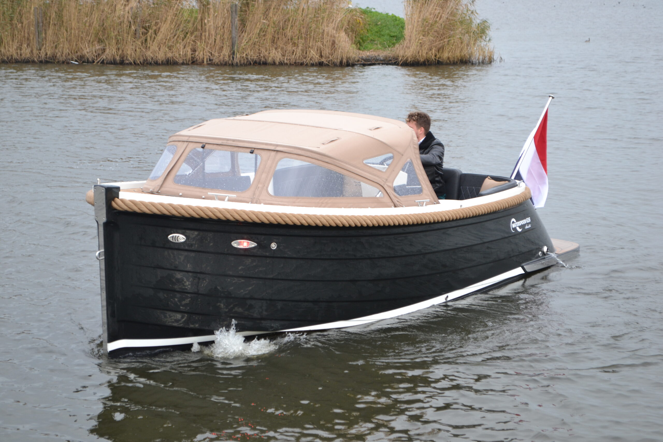 Vaartlander_Waterspoor-616-Aviator-7 Vooraanzicht van de Waterspoor 616 Aviator met opvarende aan het roer.