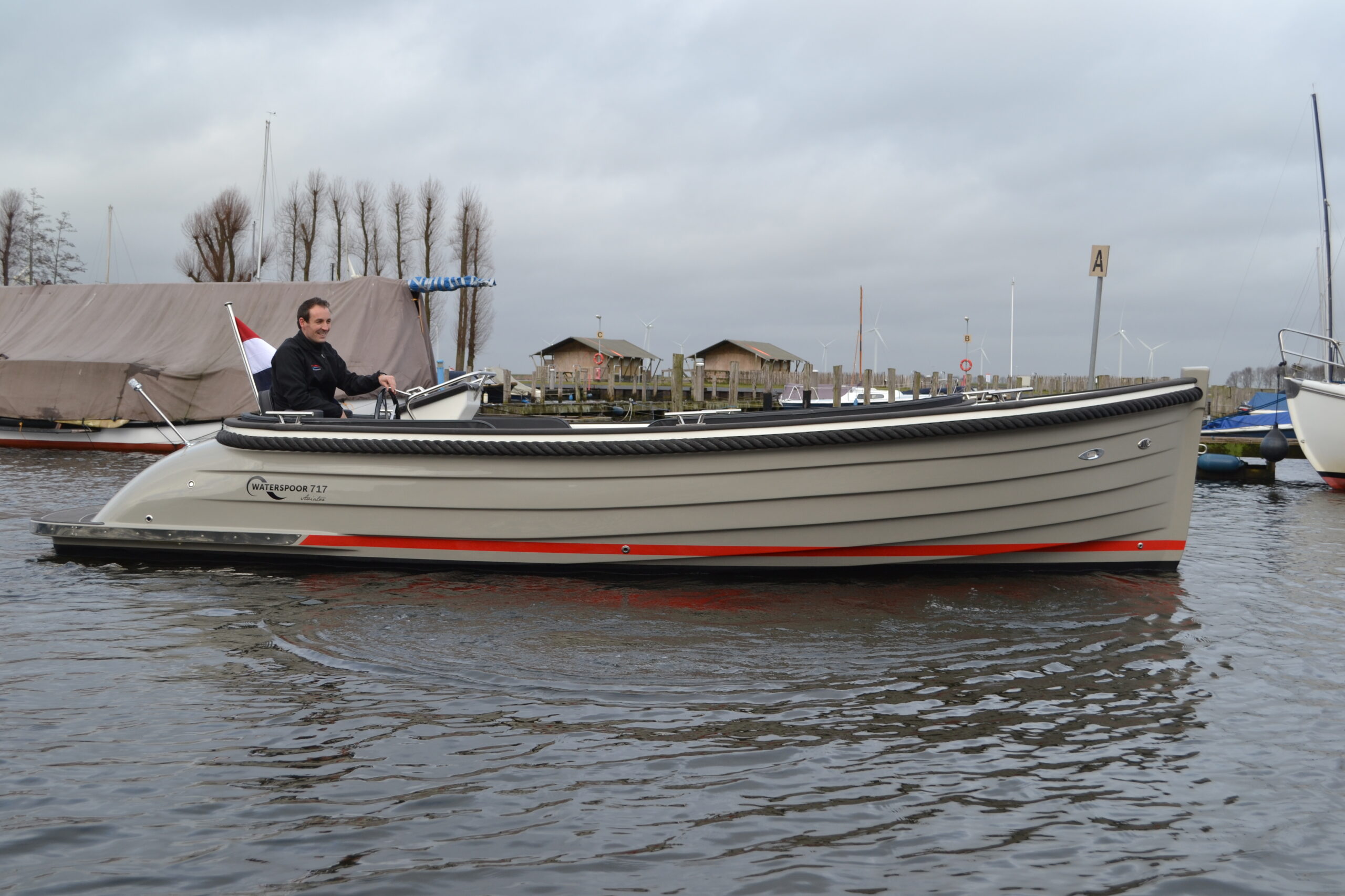 Vaartlander_Waterspoor-717-Aviator-1 Waterspoor 717 Aviator varend in de haven met grijze romp en rode waterlijn.