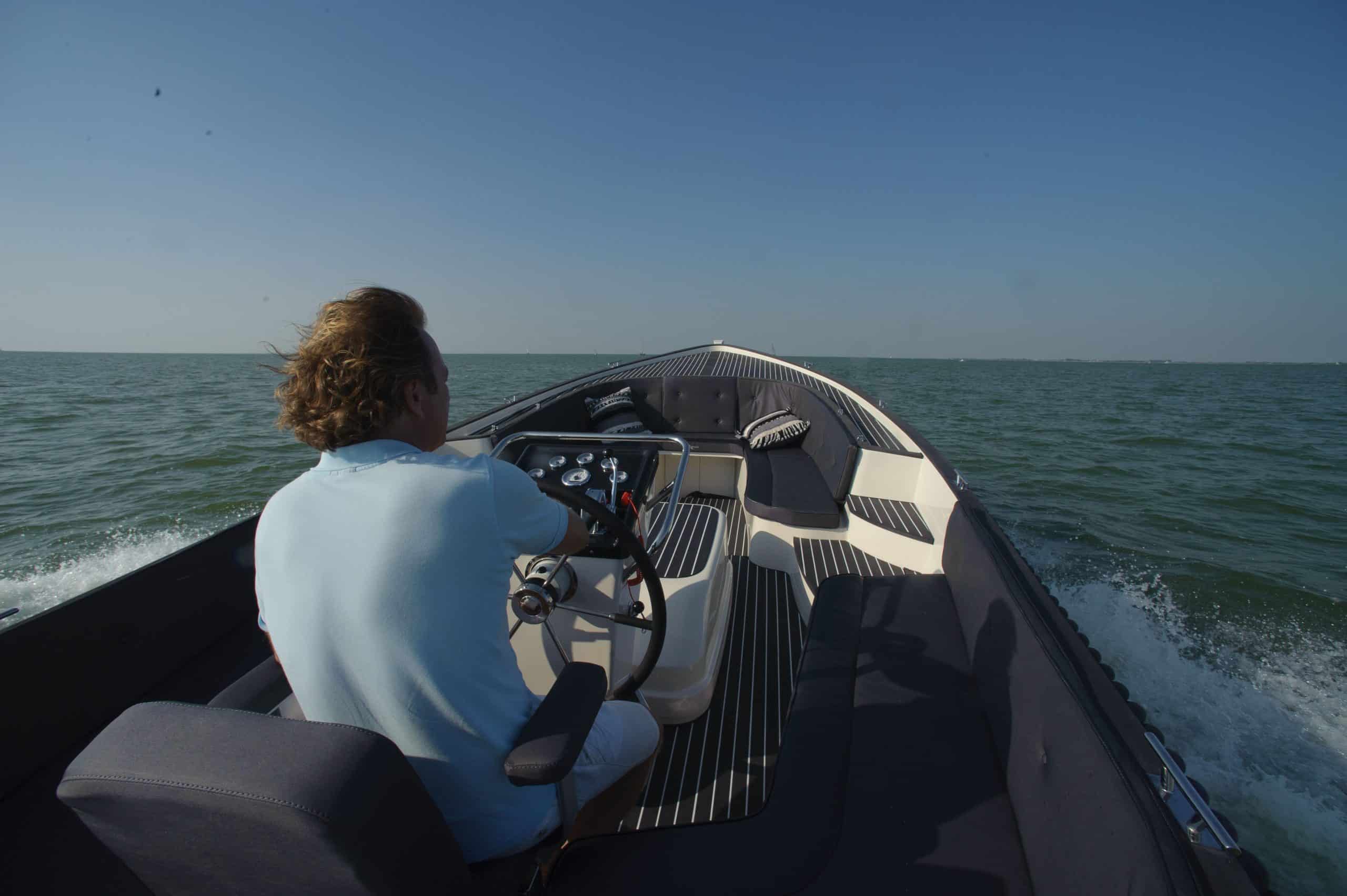 Vaartlander_Waterspoor-777-Aviator-15 Bestuurder aan het roer van de Waterspoor 777 Aviator varend op open water.